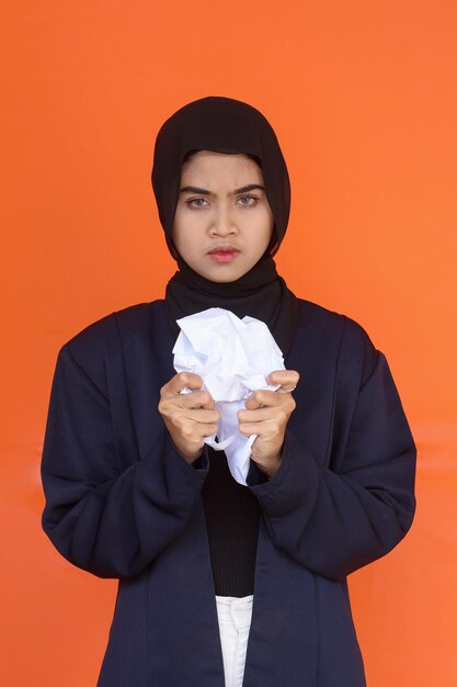 Annoyed frustrated muslim businesswoman crumpling papers, feeling angry nervous and negative or havi