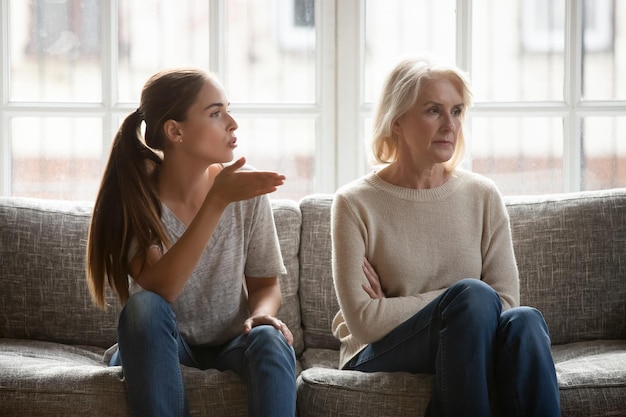 annoyed grown up daughter expressing complaints to elderly mother