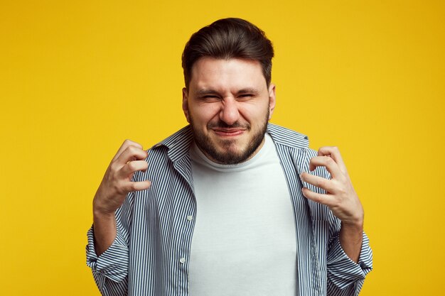 青いシャツを着たイライラした男が黄色に対して怒ってジェスチャー