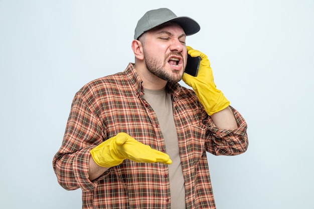 Annoyed slavic cleaner man with rubber gloves yelling at someone on phone 