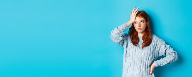 いらいらし、疲れた赤毛の 10 代の少女ロール目 facepalm とため息をつく迷惑立っているセーター a