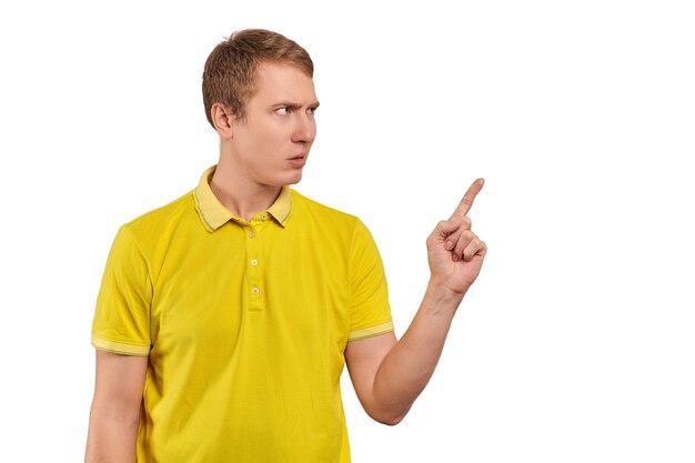Раздраженный молодой человек в желтой футболке угрожает быть более внимательным жестом пальца на белом фоне