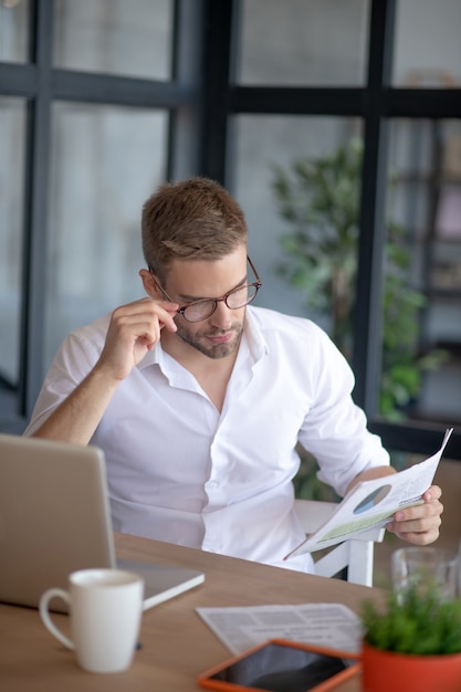 Annual growth. A manager reading a sales report at his workplace