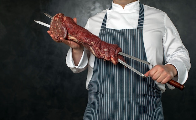 Foto anonieme chef-kok die vleespennen met vlees