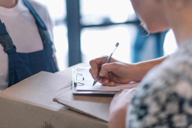 Anonieme vrouw die voor pakket ondertekent