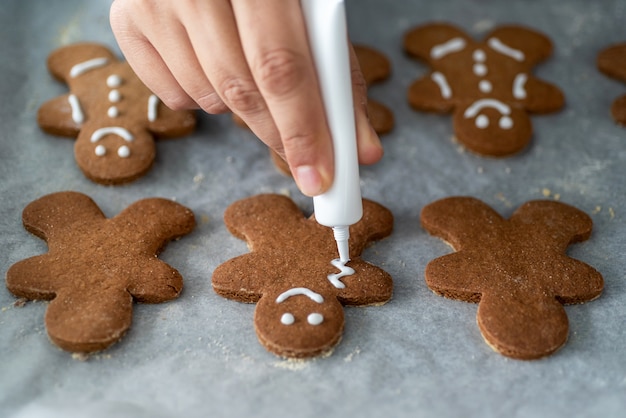 Anonieme vrouw die zelfgemaakte peperkoekmannen verfraait