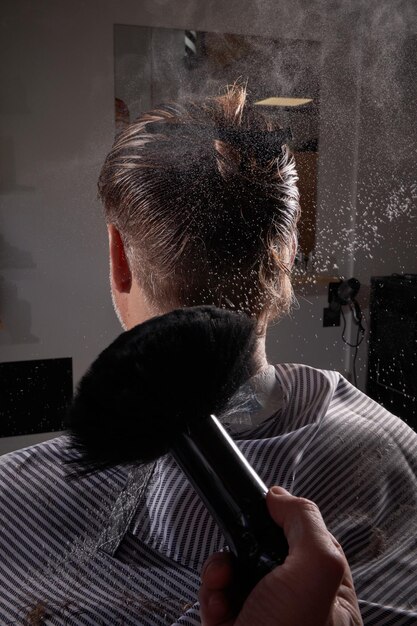 Anonymous barber with brush near client