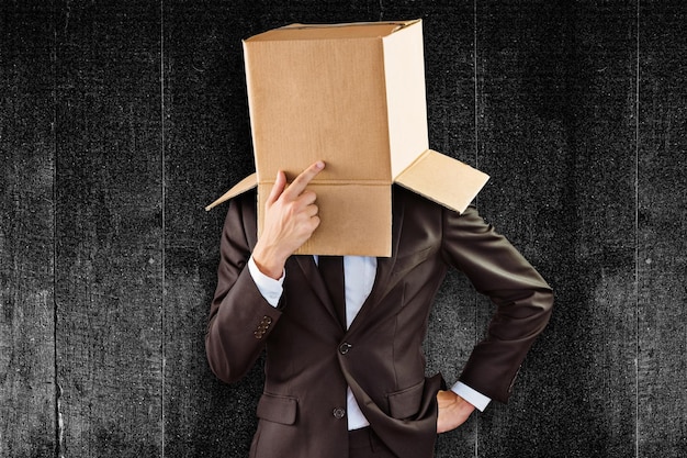 Photo anonymous businessman touching his chin against black background