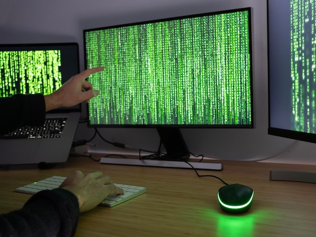 Foto hacker anonimo che punta con il dito sullo schermo concetto di avvertenza per i difetti di sicurezza di internet