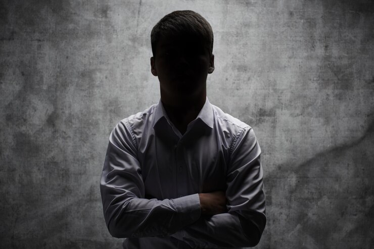 Photo anonymous man in a business shirt with arms crossed against a dark background