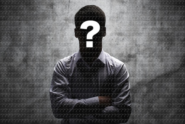 Photo anonymous man in a business shirt with question mark on his face on dark background