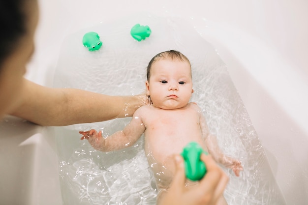 Photo anonymous mother washing baby