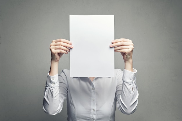 Anonymous woman covering face with paper sheet