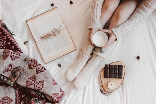 Anonymous woman with milk relaxing on bed