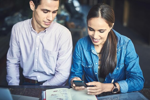 Another client has just texted with some positive feedback Shot of two designers having a meeting at a coffee shop