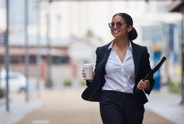 Еще один день работы на пути к успеху. Снимок привлекательной молодой деловой женщины, идущей по городу во время утренней поездки на работу.