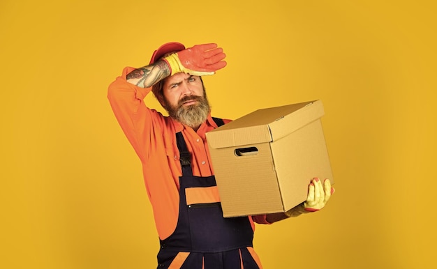 Another great reason to lease your home carrying boxes inside the building unpacking moving boxes new house at moving day man builder hold boxes moving to new apartment tired man cardboard box