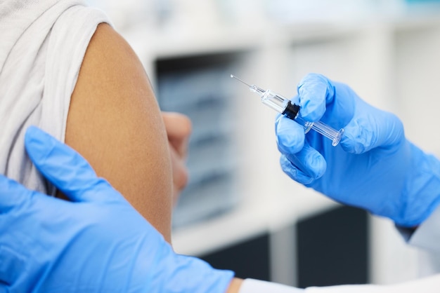 Another life saved Cropped shot of an unrecognizable doctor injecting her patient with the Covid vaccine in her clinic