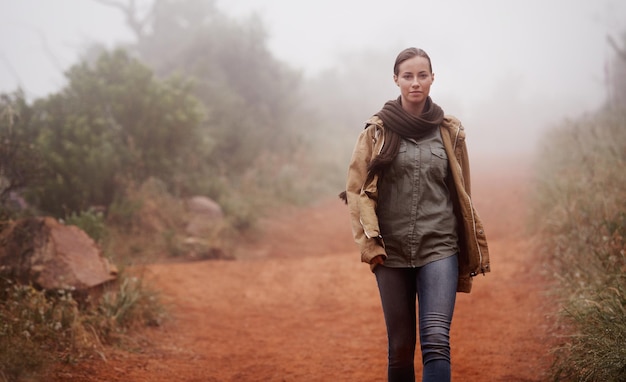 Another misty morning meander An attractive young woman out for a walk in the mountains