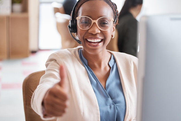 Another problem solved Cropped portrait of an attractive young female call center agent giving thumbs up while working at her desk in the office