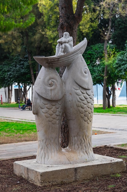 Antalya Turkije 08 februari 2023 moderne sculptuur van eenvoudige geometrische vormen met een witte sculptuur van twee vissen die een boot vasthouden en een grootvader erop