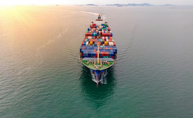 Antenne voor vrachtschip met container en rennend met bemanning dat werktouw klaarstaat voor sleepboot