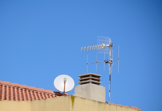 Antennes en schoorsteen op een Italiaans dak