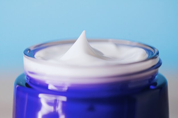 Anti-aging huidverzorging en cosmetica schoonheid gezichtscrème in pot op blauwe achtergrond