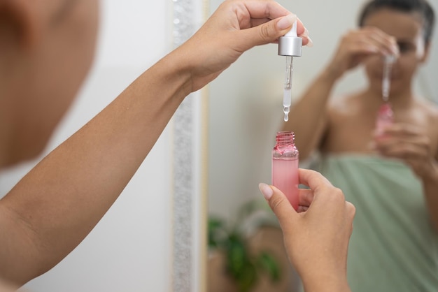 Anti-aging routine vrouw past hyaluronzuur serum aan met behulp van een druppelaar die haar huidverzorging verbetert