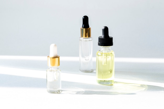 Photo anti aging serum with collagen and peptides in glass bottles with dropper on white