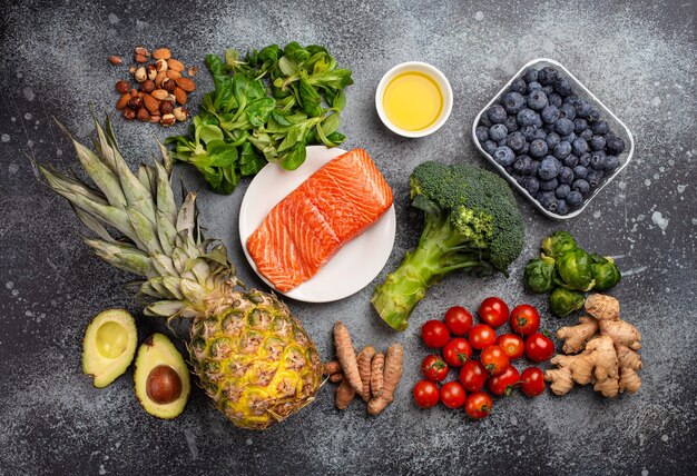 Concetto di dieta antinfiammatoria. set di alimenti che aiutano a ridurre l'infiammazione - ingredienti a base di piante, frutta fresca, verdure verdi. prodotti dietetici sani, vista dall'alto, sfondo di pietra