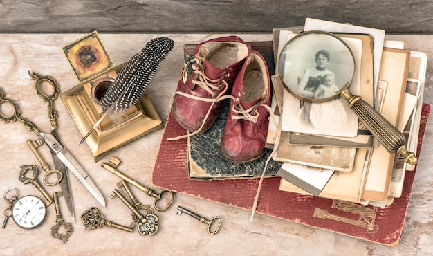 Foto antieke boeken en foto's sleutels schrijfaccessoires en babyschoentjes