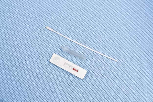 Antigen test kit ATK Covid19 negative test result on light blue color background with a cassetteextraction tubecotton swab