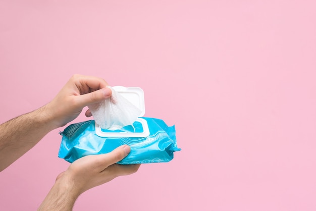 Photo antimicrobial napkin for hand disinfection during a coronavirus pandemic on pink background. space for text .