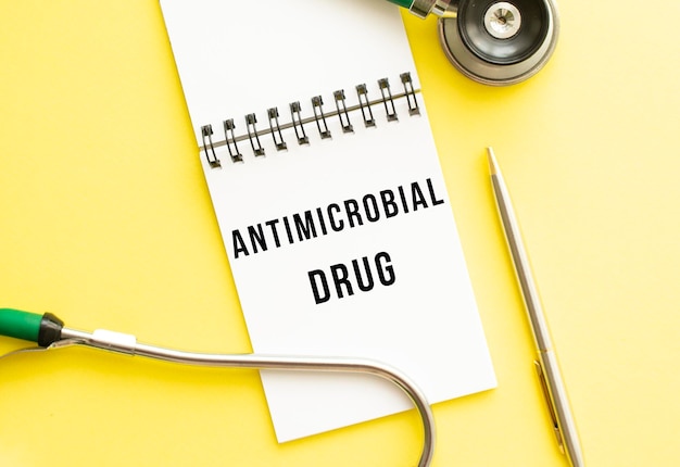 Antimicrobieel medicijn is geschreven in een notitieboekje op een kleurentafel naast een pen en een stethoscoop