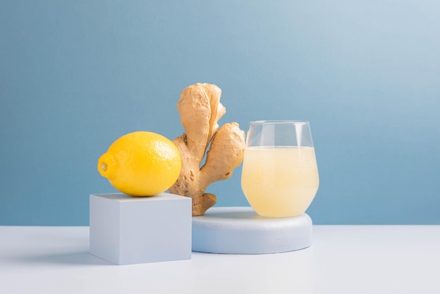 Antioxidant drink fresh ginger lemon in a glass trendy blue background podium minimalism balance