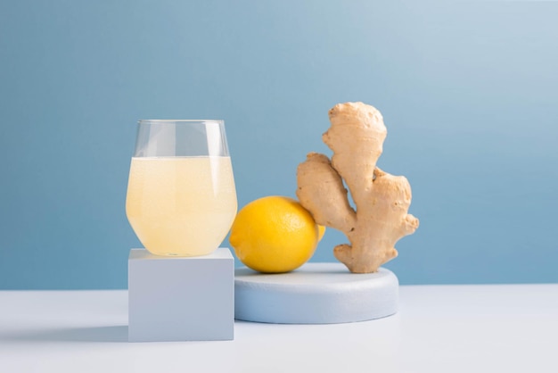Antioxidant drink verse gember citroen in een glas trendy blauwe achtergrond podium minimalisme balans