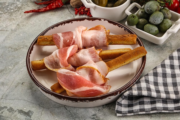 Foto antipasti grissini con pancetta di maiale