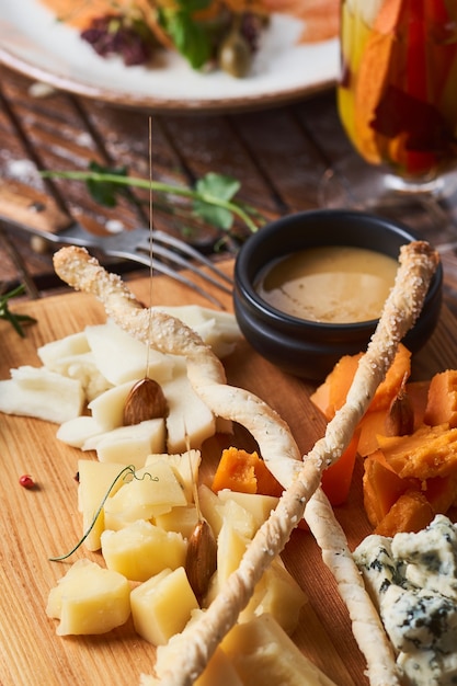 Antipasti, verschillende soorten kaas op een houten bord met honing