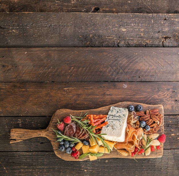 Antipasto background Different Italian snacks with fruit nut on a rustic background