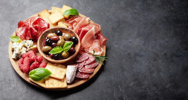 Tagliere di antipasti con prosciutto, salame, cracker, formaggio e olive con spazio per la copia