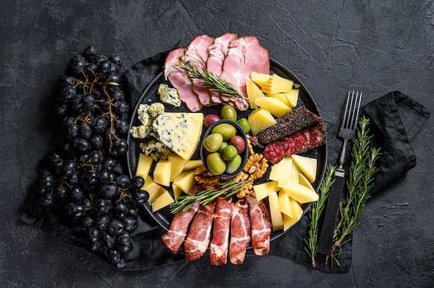 Antipasto board with sliced meat, ham, salami, cheese, olives. Top view