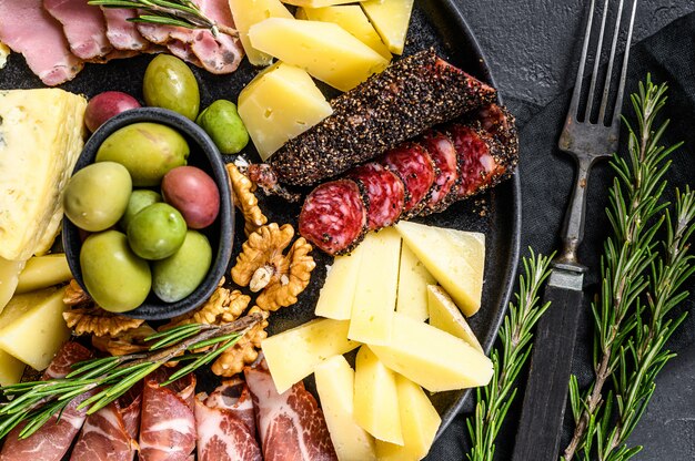 Antipasto board with sliced meat, ham, salami, cheese, olives. top view