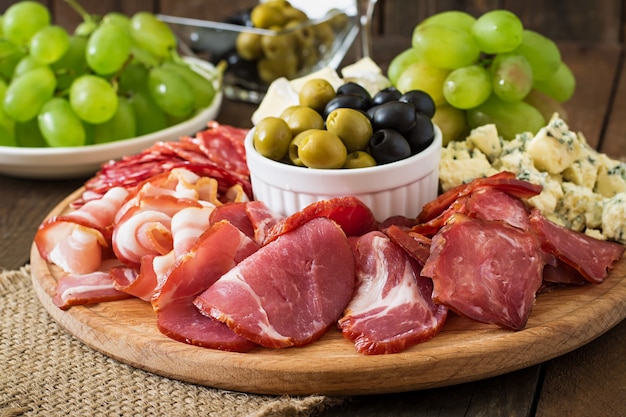 Antipasto catering platter with bacon, jerky, salami, cheese and grapes  