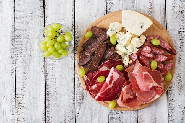 Antipasto catering platter with bacon, jerky, sausage, blue cheese and grapes