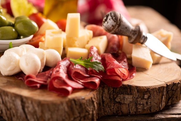 Foto piatto catering di antipasti con olive, jerky, salame e formaggio da vicino