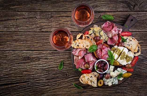Antipasto platter with ham, prosciutto, salami, blue cheese, mozzarella with pesto and olives. Top view, overhead