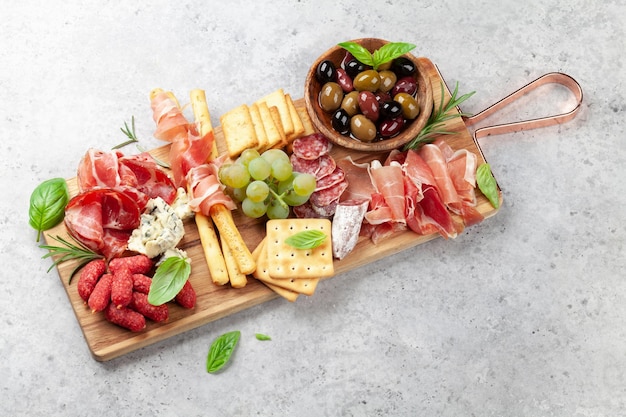 Photo antipasto with prosciutto salami crackers cheese and olives