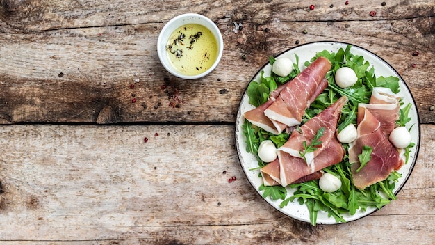 Antipastoschotel met ham, prosciutto, mozzarella en rucola