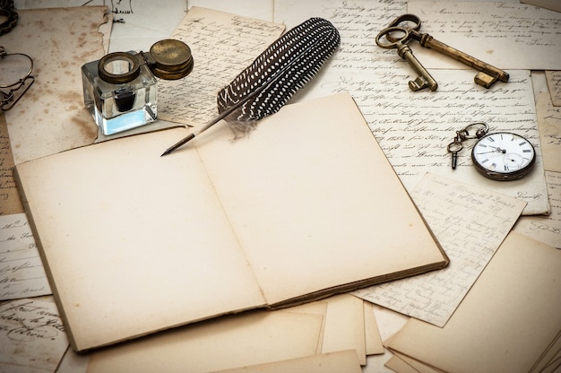 Photo antique accessories, old letters, inkwell and vintage feather ink pen. nostalgic sentimental paper background. selective focus